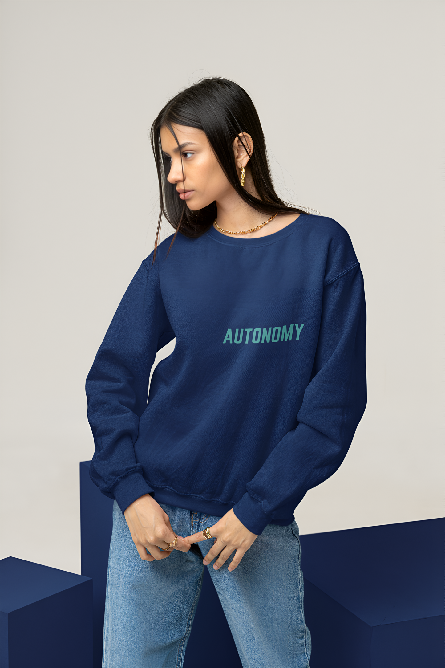 A female student wearing a good quality sweatshirt of Navy Blue color with Autonomy written over it